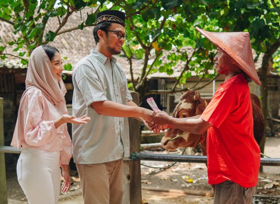 Indonesian cattleman feeling relieved after closing deal from Asian Muslim couple buying livestock cows for sacrifices. Eid Al Adha concept.